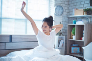 women is in bed and is waking up in the morning. She felt very refreshed.