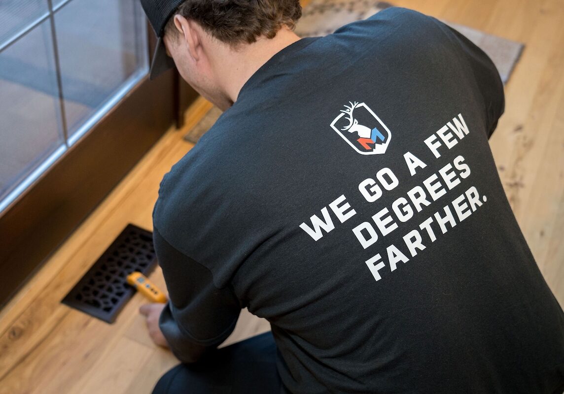 Monarch AC testing vent airflow Monarch employee wearing a shirt that states "We go a few degrees farther"