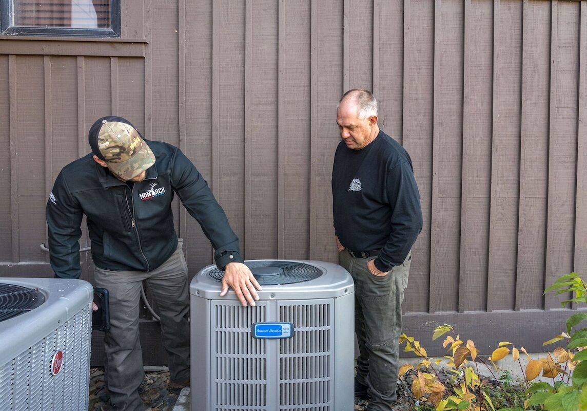 heat pump discussing with costumer Monarch employee explaining heat pump system to customer