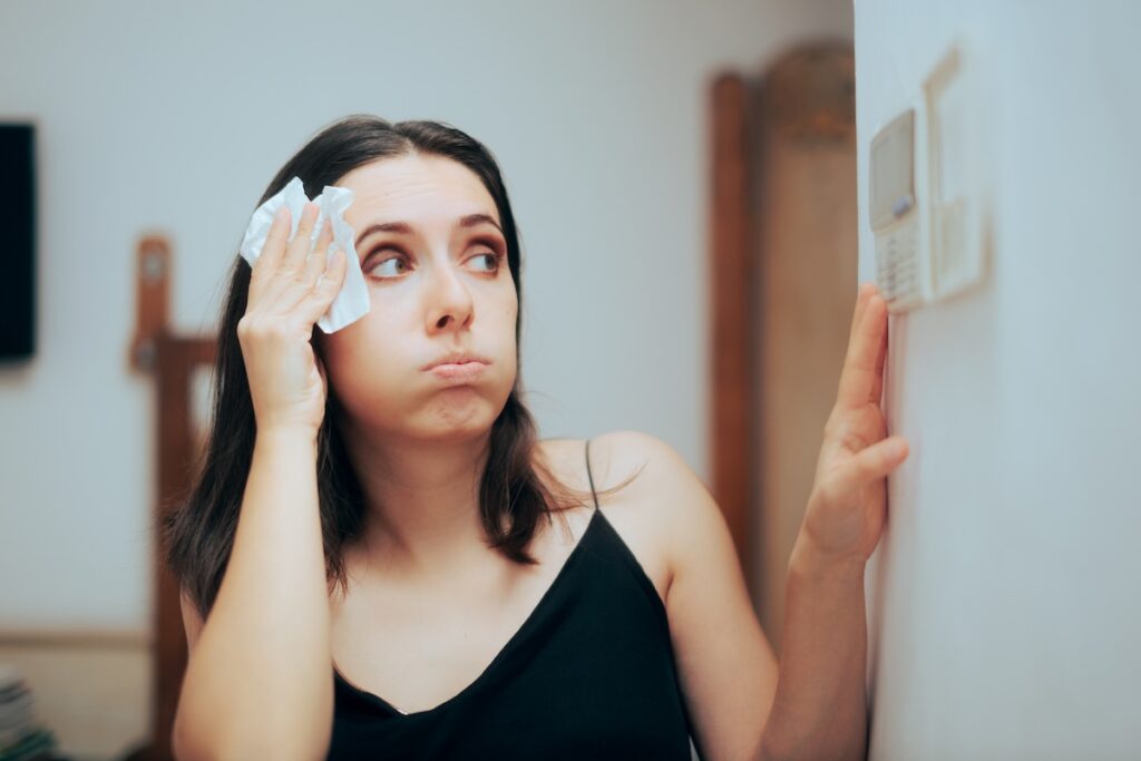 Broken thermostat with moan wiping sweat from forehead