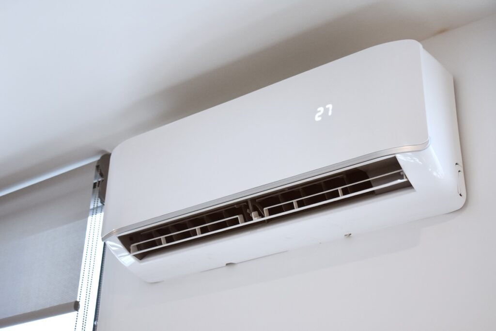 Air conditioning unit on bedroom wall Air conditioning unit attached to wall of home with digital temperature