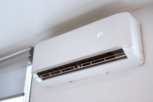 Air conditioning unit attached to wall of home with digital temperature