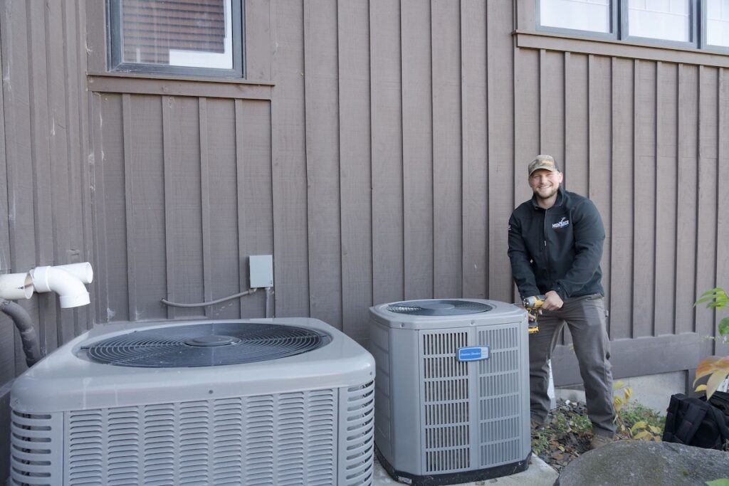 Heat pump outside, Monarch technician smiling