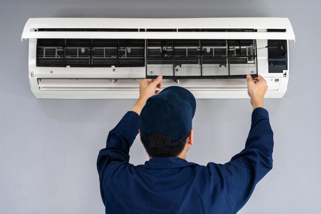 technician service removing air filter of the air conditioner for cleaning