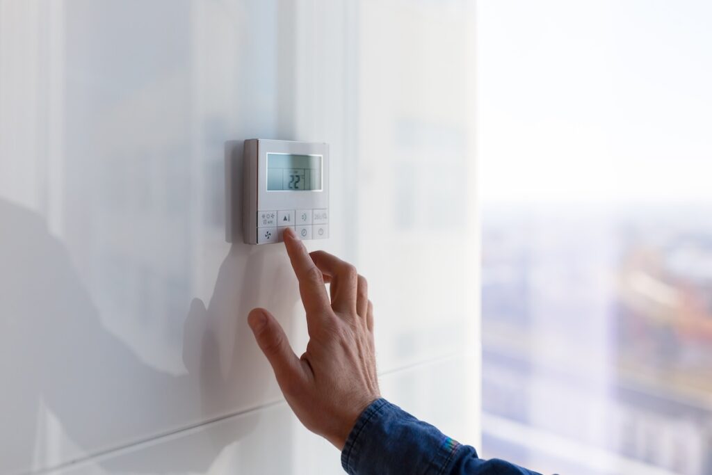 The air conditioning and heating control panel for the apartment and office is located on a white wall The air conditioning and heating control panel for the apartment located on wall